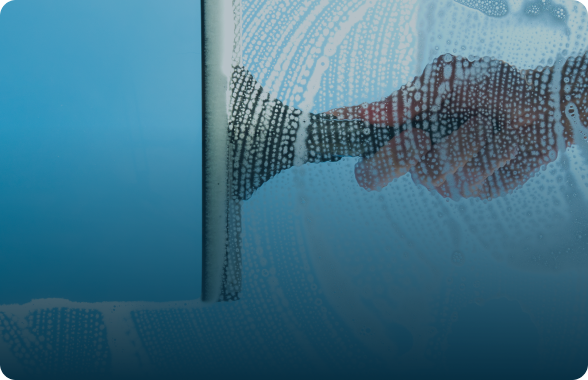 person washing window with squeegee